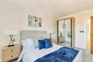 賓福特的住宿－2 Bedroom Penthouse in Brentford，一间卧室配有一张带蓝色枕头的大床