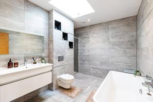 賓福特的住宿－2 Bedroom Penthouse in Brentford，浴室配有卫生间、盥洗盆和浴缸。