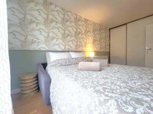 - une chambre avec un grand lit et une couverture blanche dans l'établissement Appartement moderne 2 chambres, à Saint-Maurice