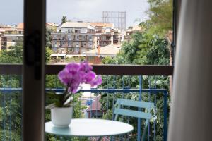 stół i waza z fioletowymi kwiatami na balkonie w obiekcie Zaccardi Roof Garden w Rzymie