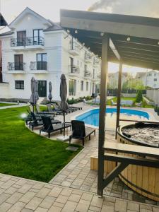 a courtyard with chairs and a pool and a building at Royal Boutique in Râşnov