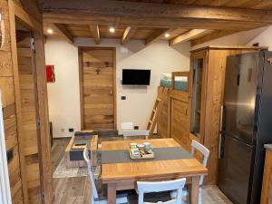 eine Küche mit einem Holztisch und einem Kühlschrank in der Unterkunft monolocale incantevole in Sordevolo