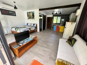 uma sala de estar com um sofá, uma cama e uma televisão em Rangiroa Cottage em Avatoru