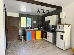 a kitchen with a white refrigerator freezer in a room at Rangiroa Cottage in Avatoru