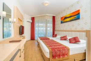 a hotel room with two beds and a television at Gardenia Hotel in Alanya