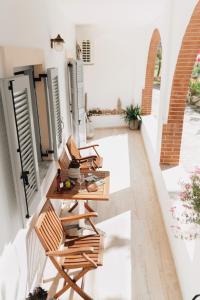a balcony with chairs and tables in a building at 3 Venti - Ostria in Liapades