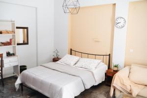 a bedroom with a bed and a clock on the wall at 3 Venti - Ostria in Liapades