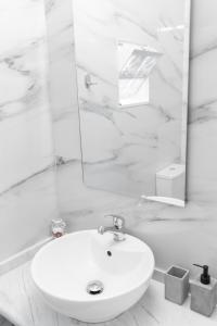 a white bathroom with a sink and a mirror at 3 Venti - Ostria in Liapades +31 photos