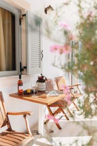 a table and chairs on a patio with a window at 3 Venti - Ostria in Liapades