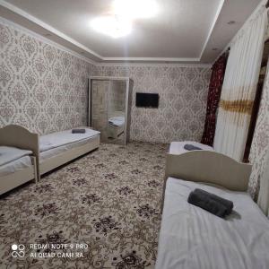 Habitación con 2 camas y TV. en Guest House Sadbarg, en Samarkand