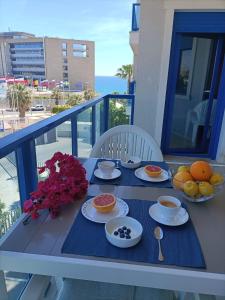 una mesa con platos de comida en el balcón en Alicante Mar, en Alicante