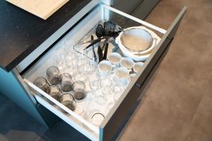 a drawer with cups and utensils in it at Ferienwohnung am Großen Garten Dresden in Dresden +22 photos