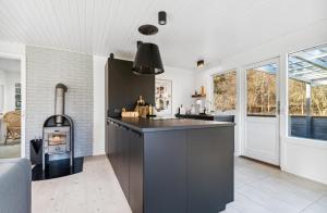 una cucina con piano cottura e bancone nero di Lovely Summer House With Bornholm Atmosphere, a Vester Sømarken