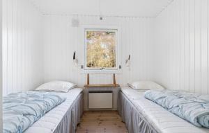 3 camas en una habitación con ventana en Lovely Summer House With Bornholm Atmosphere, en Vester Sømarken