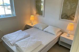 1 dormitorio pequeño con 1 cama con 2 lámparas en Modern Cottage Close To The Beach, en Vejby