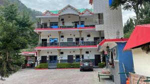 a building with a car parked in front of it at Red Rose Hotel in Bālākot