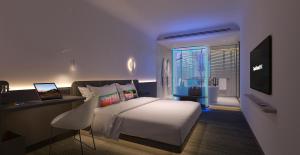 una camera da letto con un letto, una scrivania e una televisione di CapsuleTransit MAX - Airport Hotel - Landside, Public Area - Gateway KLIA T2, Lvl 2M a Sepang