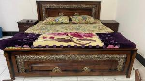 a bed with a bedspread and pillows on it at Red Rose Hotel in Bālākot