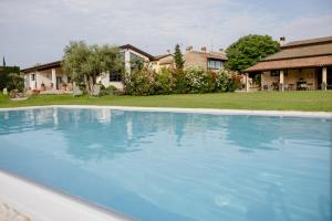 une grande piscine bleue en face d'une maison dans l'établissement Agriturismo Sambuco, à Pastrengo