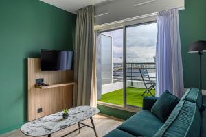 a living room with a couch and a large window at Appart Hôtel Le Liberté Vannes Centre-Ville in Vannes