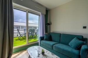 ein Wohnzimmer mit einem Sofa und einem großen Fenster in der Unterkunft Appart Hôtel Le Liberté Vannes Centre-Ville in Vannes