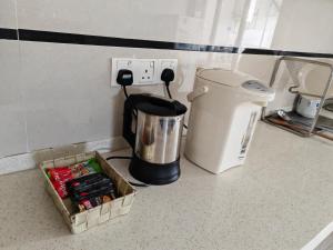 a counter top with a coffee maker and a box on it at Jee Foh Homestay in Miri