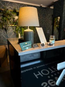 une table avec une lampe au-dessus d'un bureau dans l'établissement Seven Hotel Bytom - Katowice, à Bytom