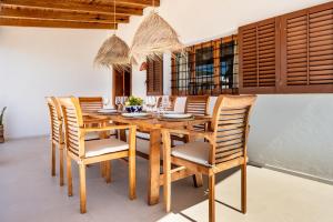 uma sala de jantar com uma mesa de madeira e cadeiras em Can Joan Durban em Sant Joan de Labritja