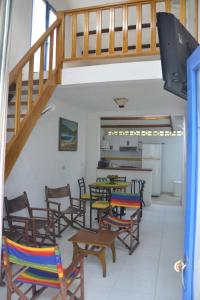 ein Zimmer mit Stühlen, Tischen und einer Treppe in der Unterkunft El Camino Los Lanceros in Melgar