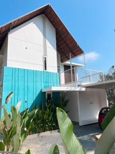 una casa con una fachada azul y blanca en CuteHug Home stay, en Kalpetta