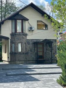 a stone house with a porch and a driveway at Cottage Zelman in Yaremche