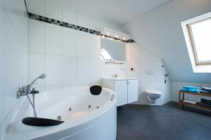 een witte badkamer met een bad en een toilet bij Ostsee-Himmelreich Großenbrode in Großenbrode
