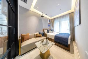 een hotelkamer met een bed en een bank bij Gangxia International Hotel-深圳福田会展中心岗厦地铁站店 in Shenzhen