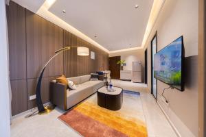 ein Wohnzimmer mit Couch und Flachbildfernseher in der Unterkunft 岗厦轻居-深圳福田会展中心岗厦地铁站店 in Shenzhen
