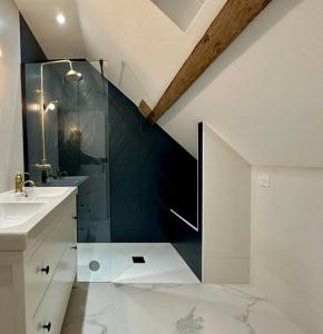 ein Bad mit einer Glasdusche und einem Waschbecken in der Unterkunft Longère des 1001 étoiles in Renay
