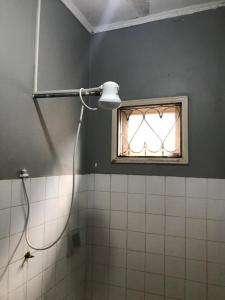 a shower in a bathroom with a window at Janibichi Adventures hostel in Moshi