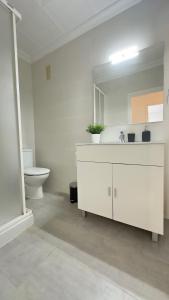 uma casa de banho branca com um lavatório e um WC em Apartamentos Vernia Ontinyent em Ontinyent