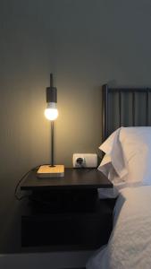 uma lâmpada sobre uma mesa ao lado de uma cama em Apartamentos Vernia Ontinyent em Ontinyent