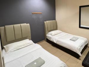 Habitación con 2 camas en una habitación en Pekan Budget Hotel, en Pekan