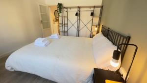 a bedroom with a large white bed with towels on it at Apartamentos Vernia Ontinyent in Ontinyent