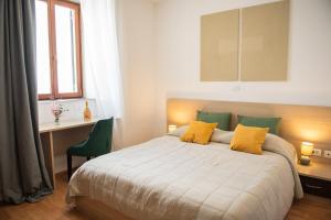 Schlafzimmer mit einem Bett, einem Schreibtisch und einem Fenster in der Unterkunft Hotel Marina in Fažana