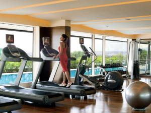 a woman standing on a treadmill in a gym at Courtyard by Marriott Pune Hinjewadi in Pune