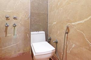a bathroom with a toilet and a stone wall at Hotel Mint Residency - Dwarka Sector 9 in New Delhi