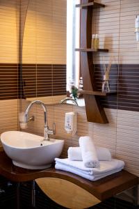 a bathroom with a sink with towels on a counter at Hotel Marina in Fažana