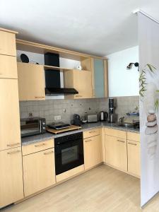 uma cozinha com armários de madeira e um forno com placa de fogão em La Pura Vida em Bühlertann