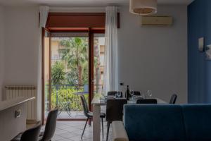een eetkamer met een tafel en stoelen en een balkon bij Sorrento Main Road Apartment in Sorrento