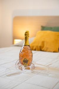 a bottle on a bed with glasses on it at Hotel Marina in Fažana