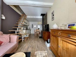 a living room with a couch and a staircase at Maison des 4 Saisons by Melrose in Bayeux +23 photos
