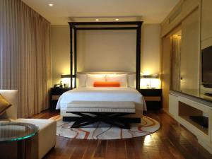 a bedroom with a bed with an orange pillow on it at Courtyard by Marriott Pune Hinjewadi in Pune