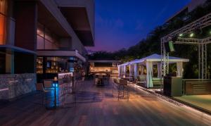 a bar with chairs and tables on a patio at night at Courtyard by Marriott Pune Hinjewadi in Pune